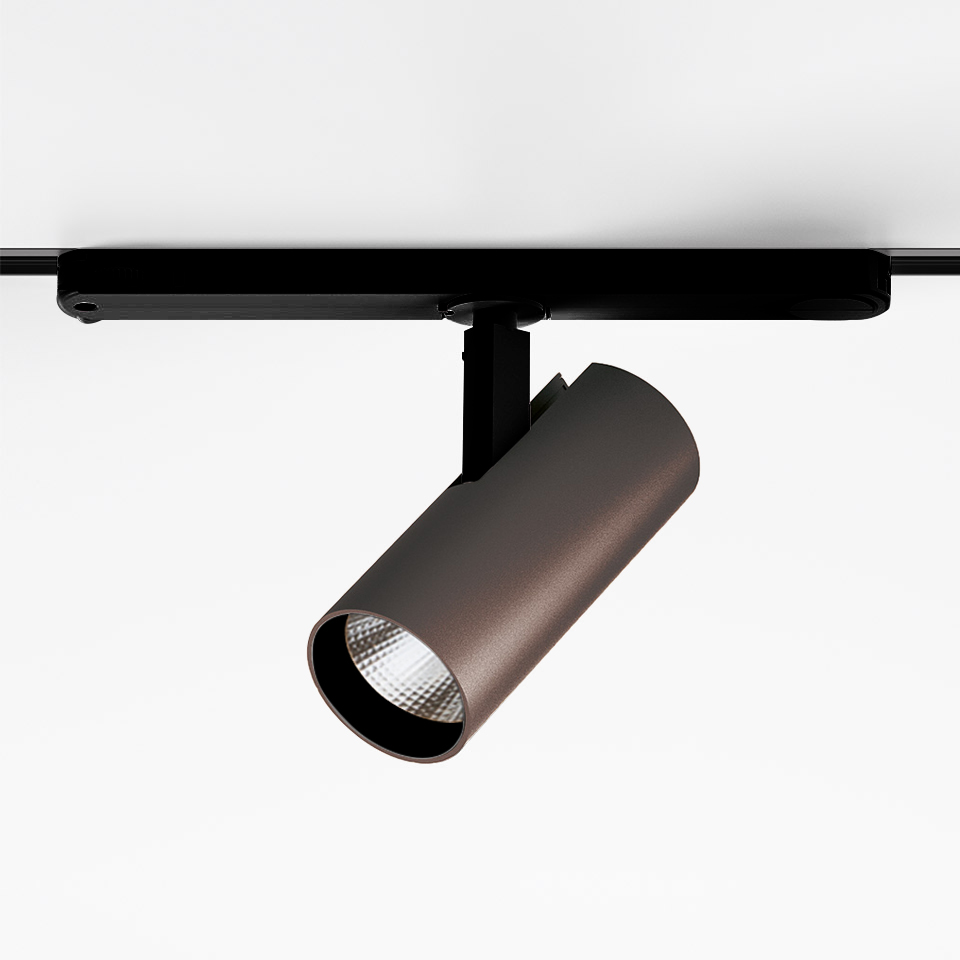 Artemide Vector Track 230V: bronze cylindrical LED spotlight mounted on black track rail, adjustable head with faceted lens