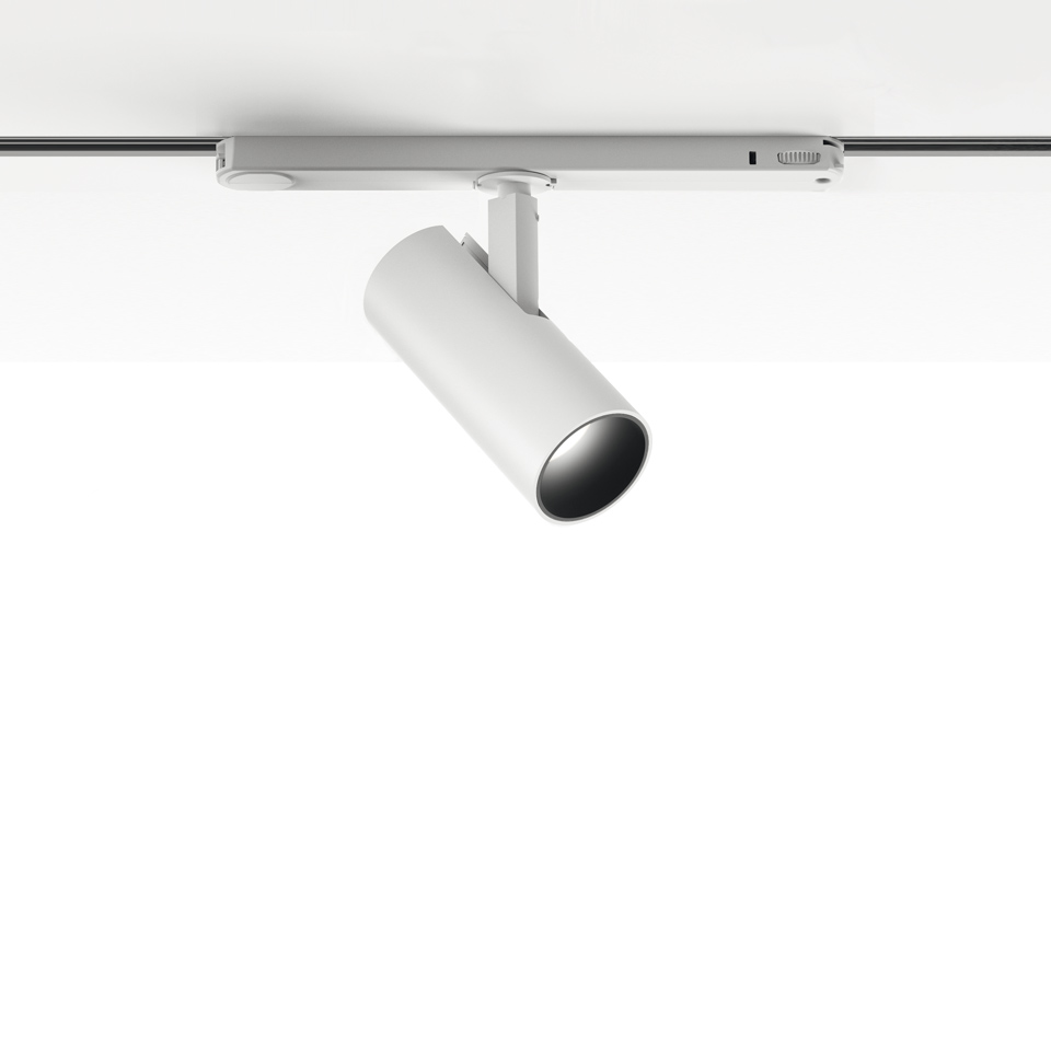 Artemide Vector Track 230V: white cylindrical adjustable spotlight mounted on a ceiling track rail, tilted at an angle