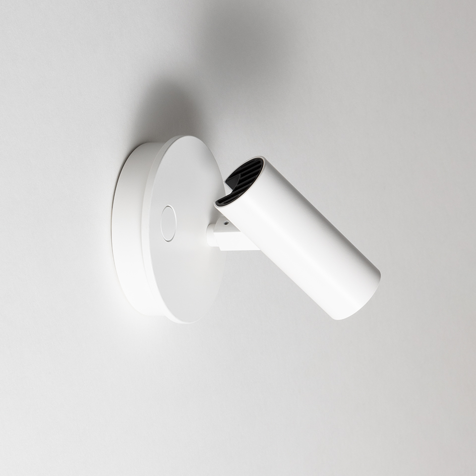 Artemide Vector Wall spotlight in white, cylindrical adjustable head mounted on round wall base, with black interior louvre