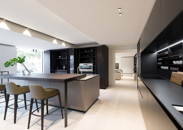 Modern kitchen with recessed ceiling spotlights, dark cabinetry, island with bar stools, and under-cabinet LED strip lighting.