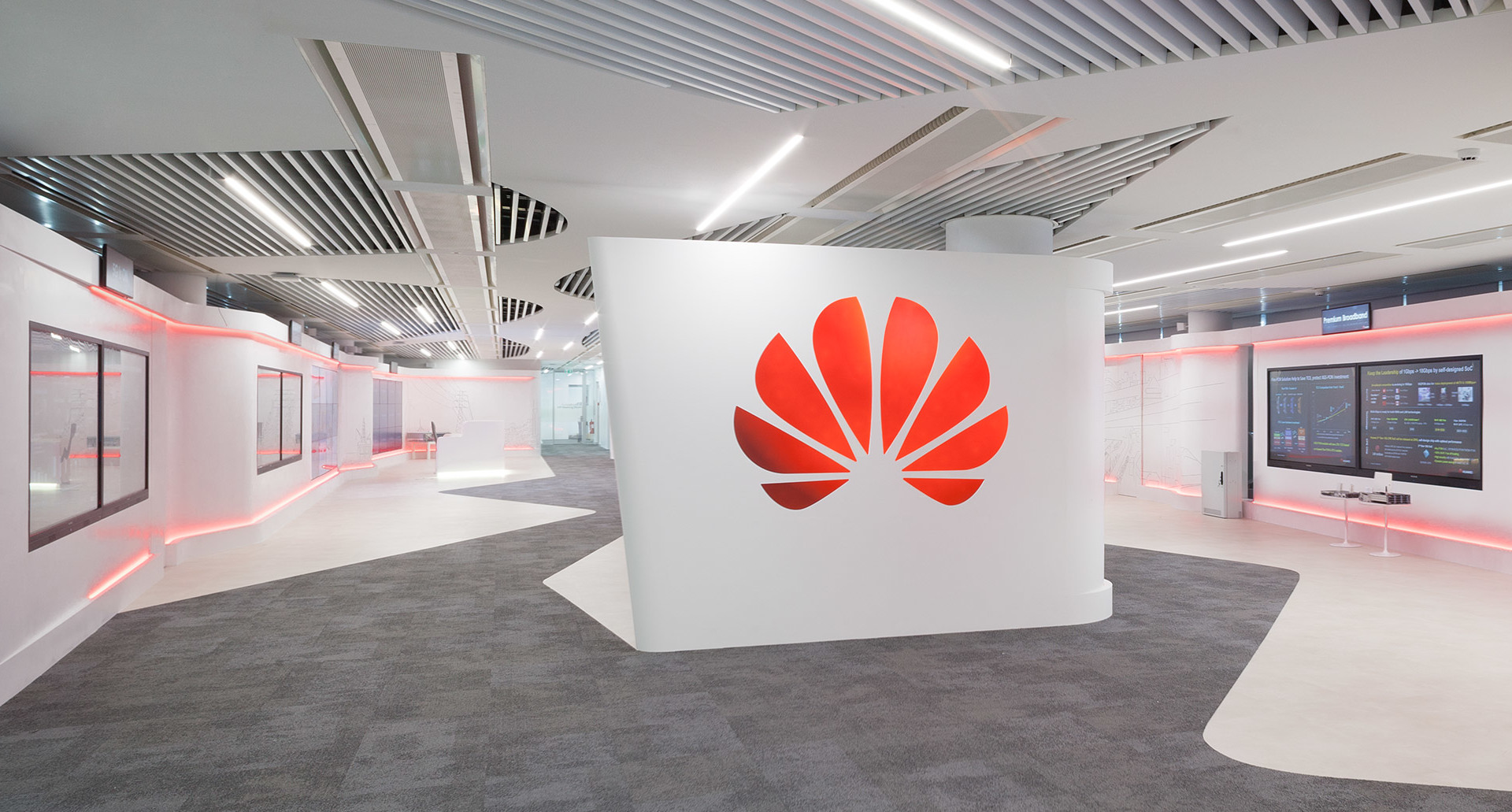 Huawei office showroom with Artemide linear ceiling lights and red LED accent lighting along white curved walls