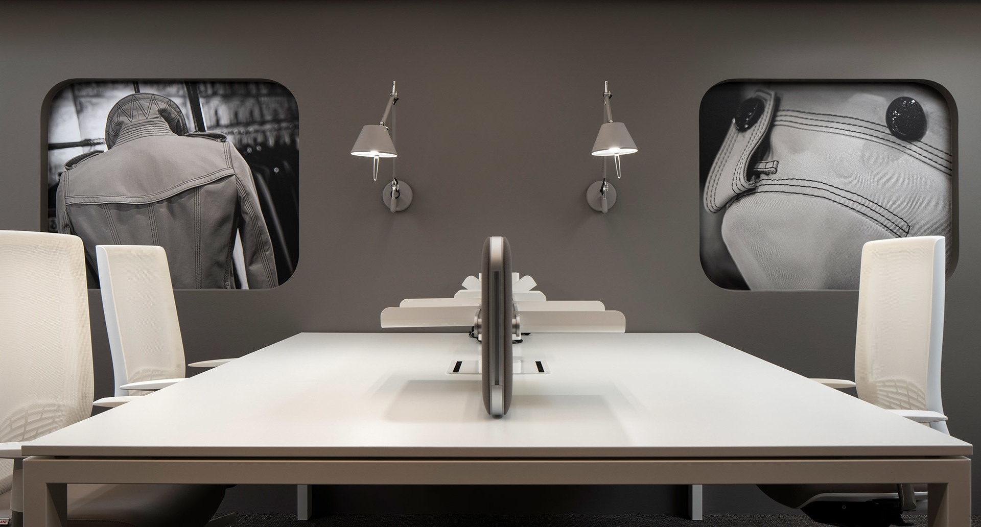 Modern office workspace with white desk and chairs, flanked by two Artemide Tolomeo wall lamps in brushed aluminum finish.