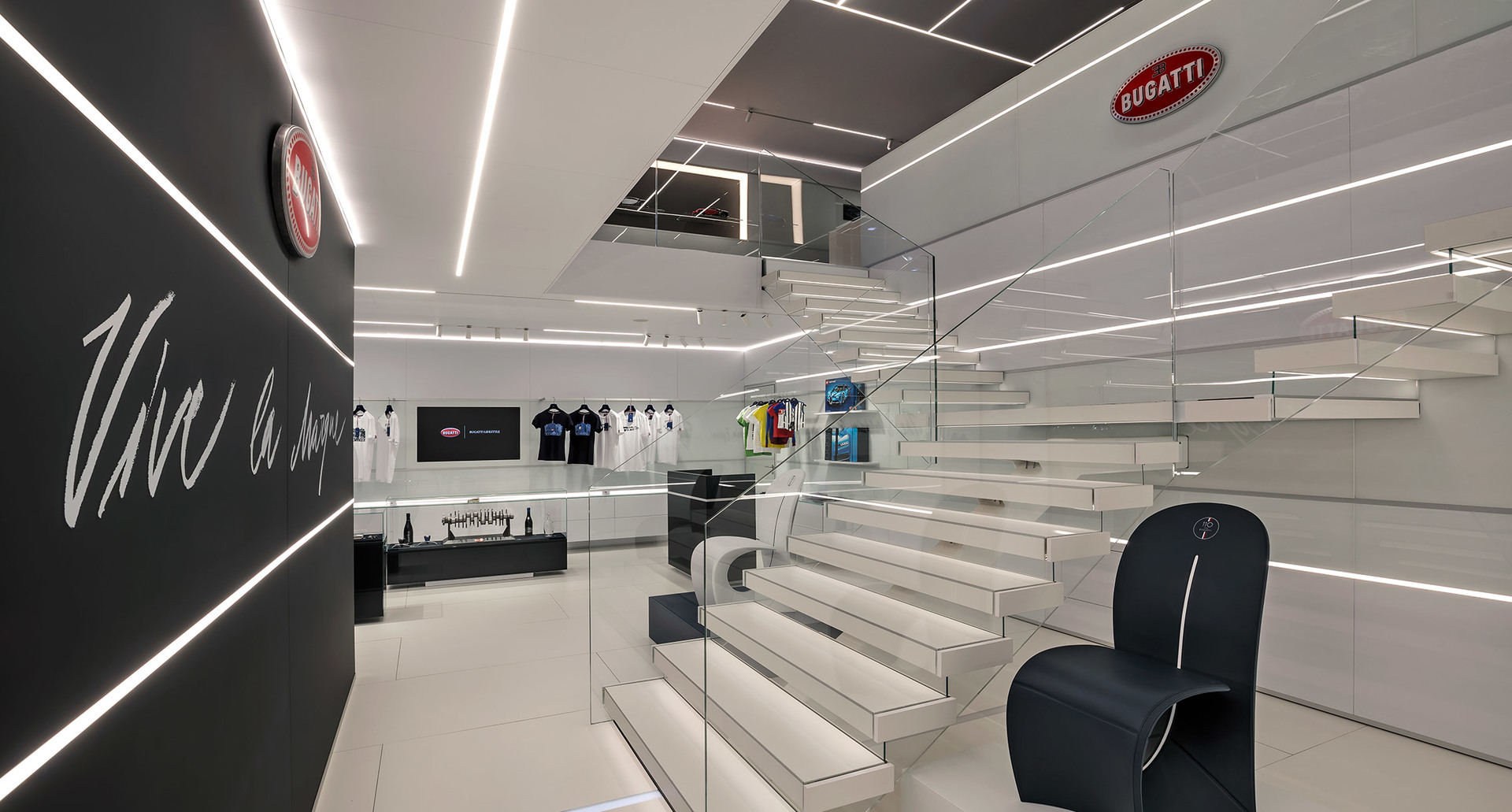 Bugatti showroom with white staircase, illuminated by Artemide linear LED ceiling lights creating geometric patterns on black and white interior