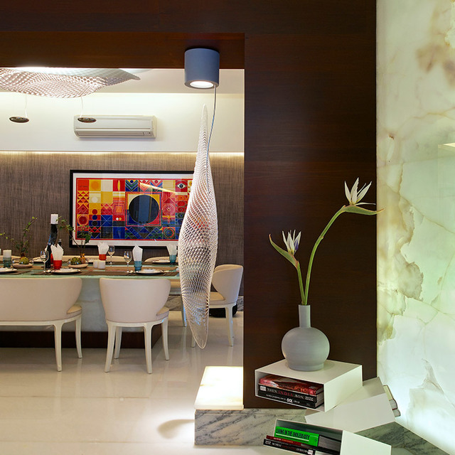 Dining room with an Artemide mesh pendant lamp hanging from a blue ceiling canopy, casting light over an elegantly set table.