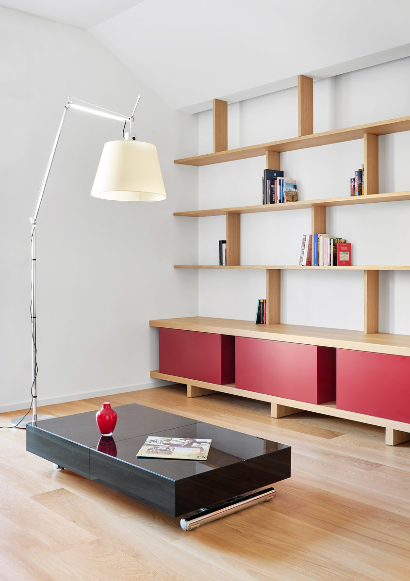 Artemide Tolomeo Mega floor lamp with white shade in a modern living room with wooden shelves and red cabinet