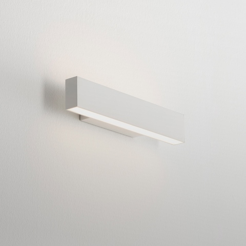 Artemide A.24 Parete wall lamp: slim rectangular white LED fixture mounted horizontally, emitting soft upward and downward light