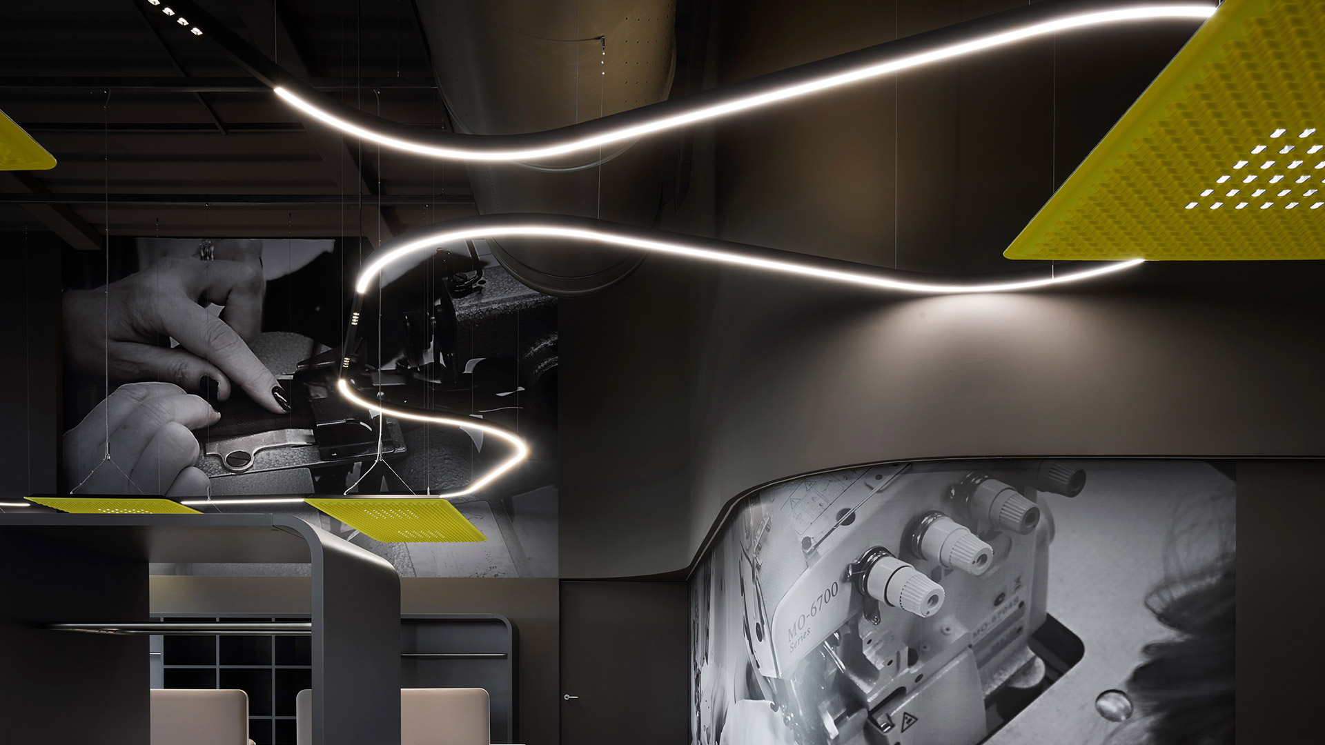 Artemide A.24 system: recessed linear LED strip forming an L-shape on wall, paired with ceiling track spotlights in a minimalist room