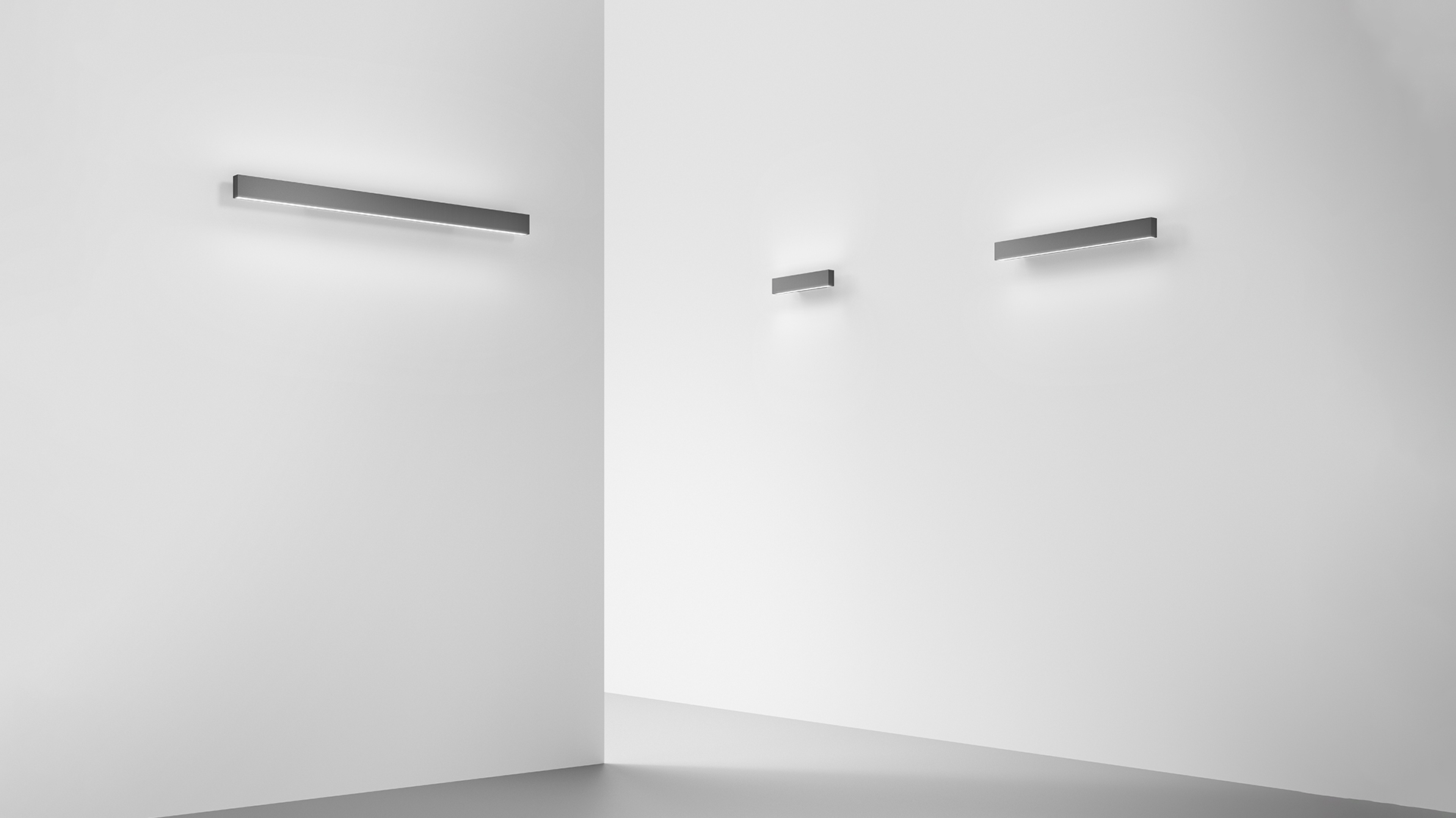Artemide A.24 Parete wall lamp: slim rectangular dark grey aluminum profile with warm white LED strip, mounted horizontally on white wall
