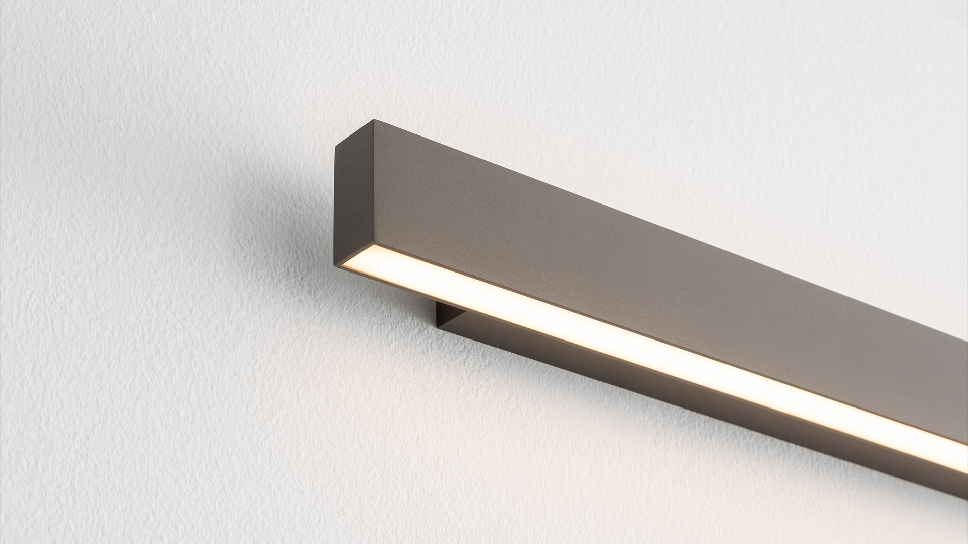 Artemide A.24 Parete wall lamp: slim elongated white LED bar mounted diagonally, emitting warm light from bottom edge