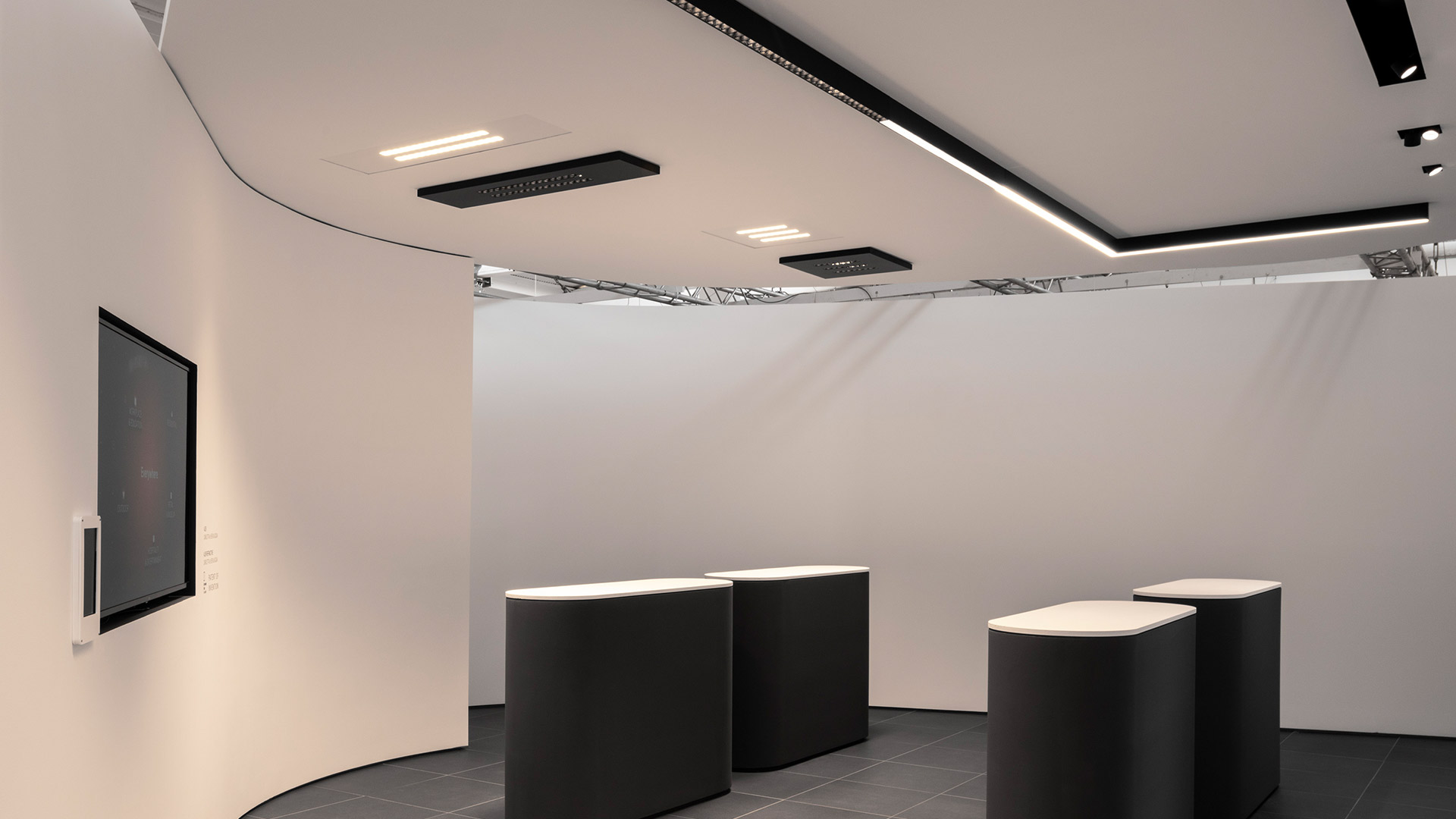 Artemide A.39 ceiling light: black linear track with a row of white refractive LED spotlights mounted flush, emitting warm light