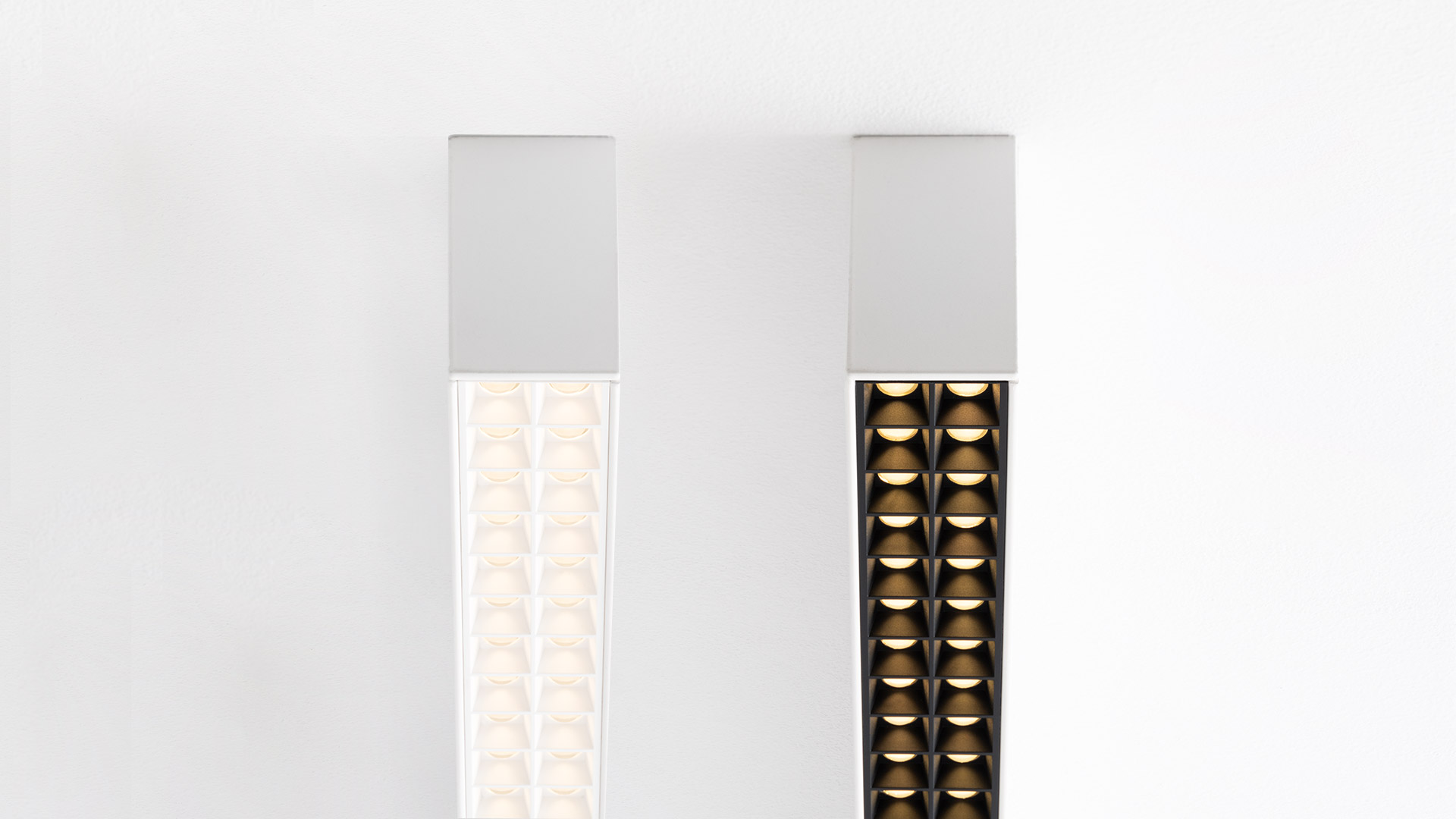 Artemide A.39 recessed ceiling light with black microrefractive grid housing multiple warm white LED modules in a linear arrangement