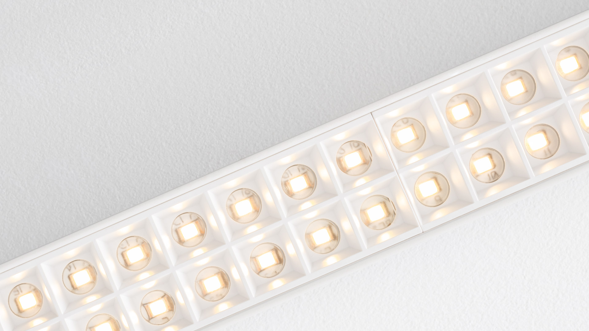 Artemide A.39 recessed ceiling light featuring a row of warm LED modules in white square reflectors, flush-mounted on ceiling