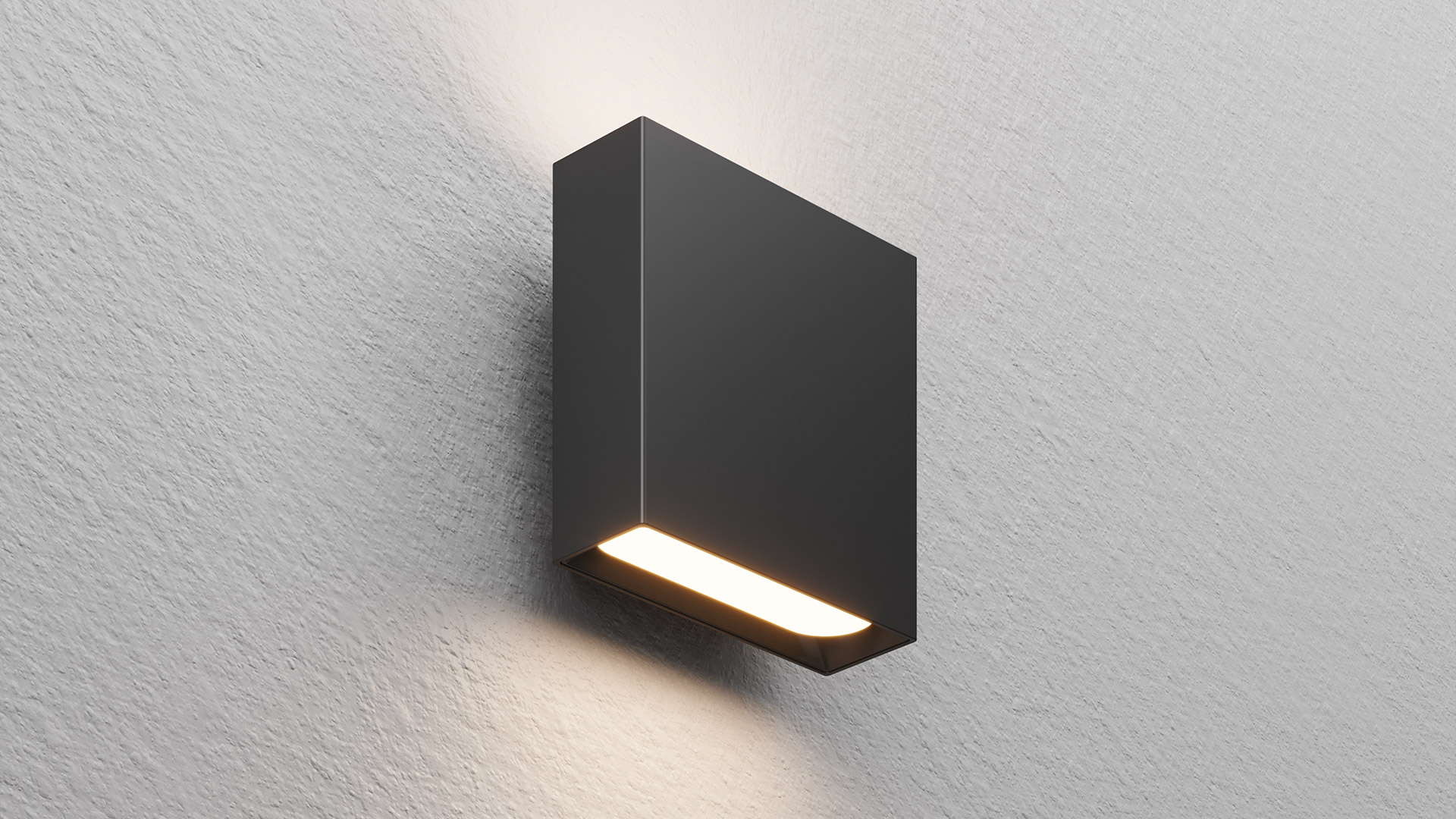 Artemide Agathe wall light: dark anthracite rectangular body mounted on white wall, emitting warm white light downward through a horizontal slot.