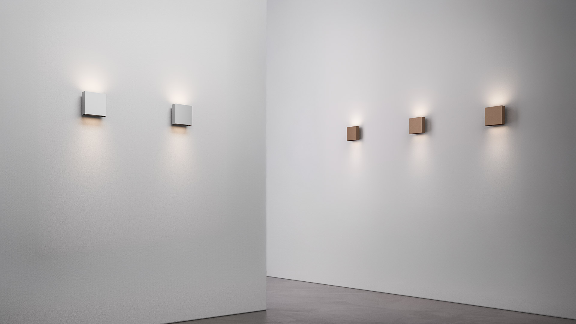 Five Artemide Agathe wall lights in a row, emitting warm downward glow, in white, light grey, copper, bronze, and dark grey finishes