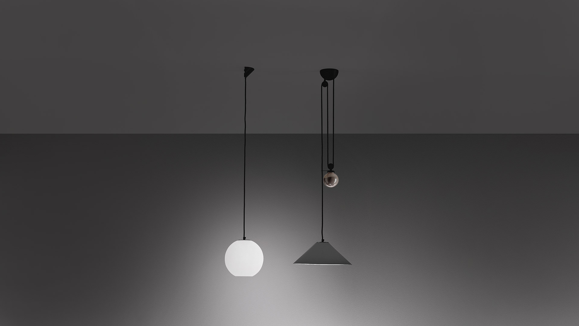 Aggregato pendant lamp with dark conical shade hanging over a wooden table with a black bowl of fruits, soft downward light.