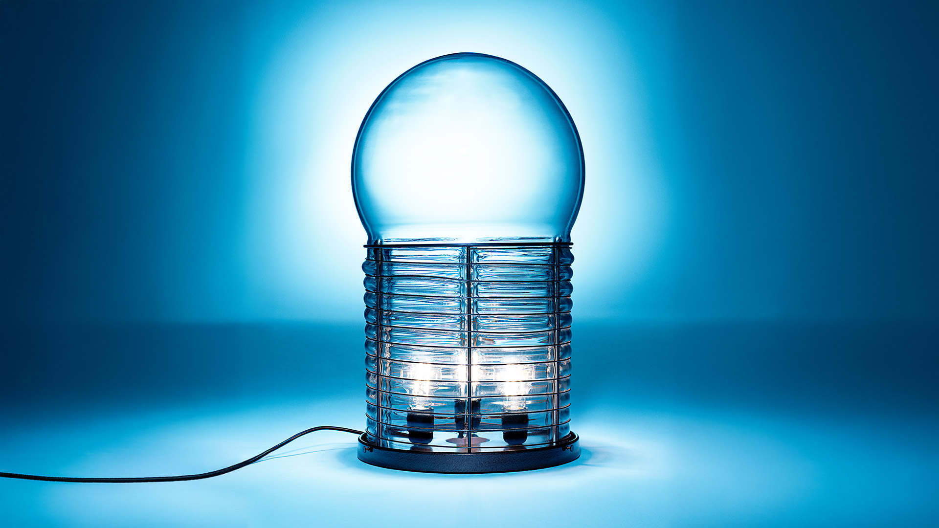 Artemide Alcinoo table lamp: frosted glass globe atop a cylindrical cage with horizontal ribs and a copper base