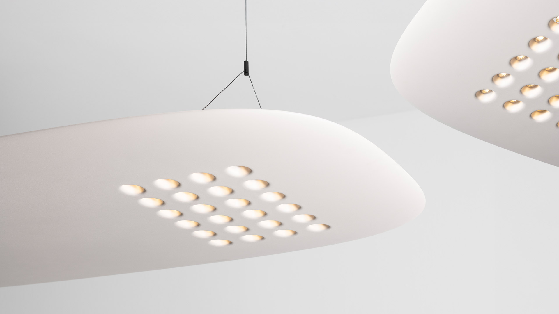 Artemide ALE.01 oval pendant lamp in warm white, suspended by two cables, featuring a grid of warm LED dots on its underside