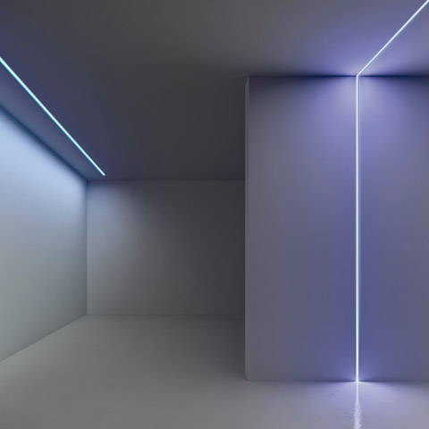 Minimalist white room with Artemide Algoritmo System linear LED lights tracing ceiling edges and a vertical corner, emitting cool blue-white light