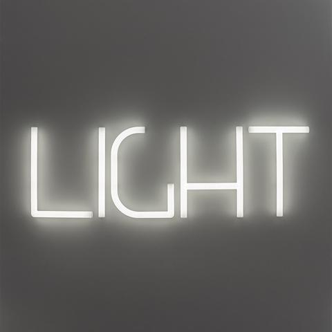 Artemide Alphabet of Light: the word LIGHT spelled in illuminated white LED tubular letters mounted on a grey wall