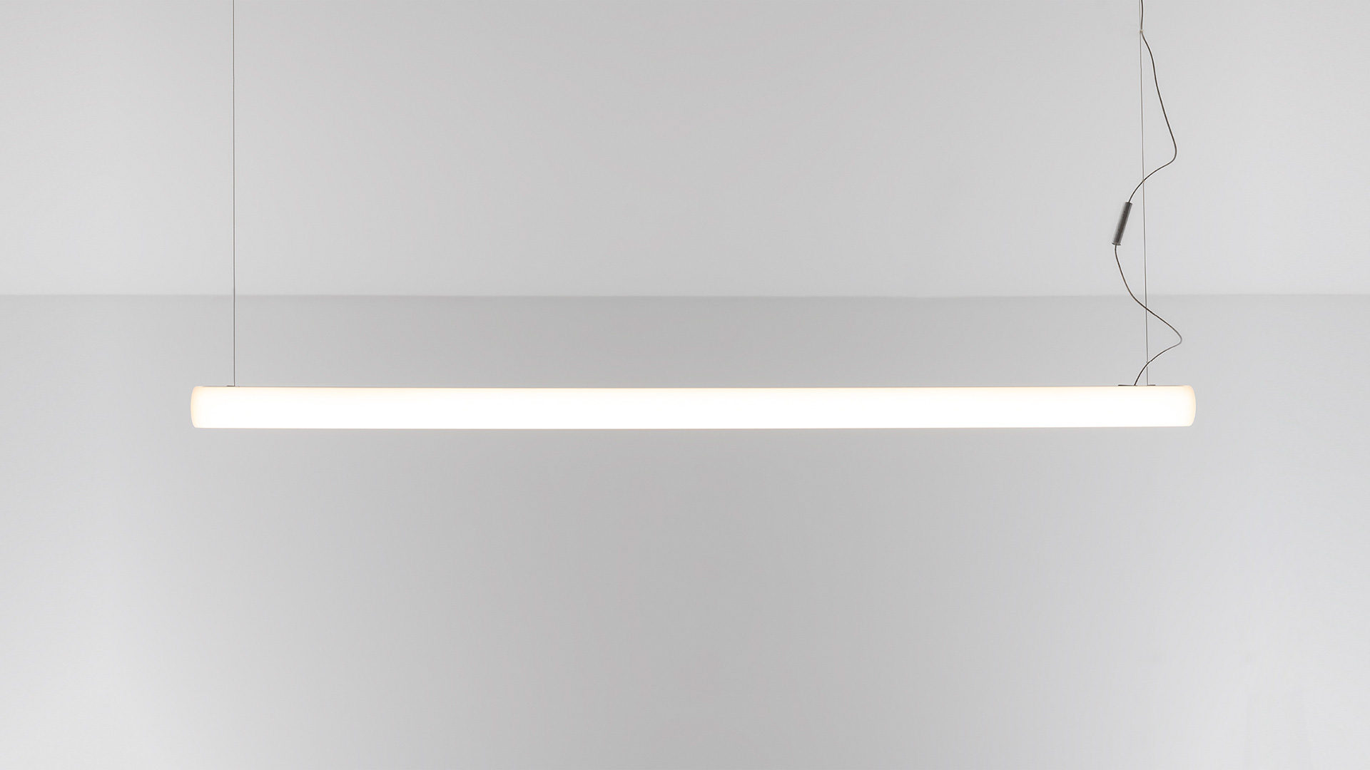 Artemide Alphabet of Light Linear pendant lamps forming a large loop over a marble reception desk at Associazione Italiana Sommelier