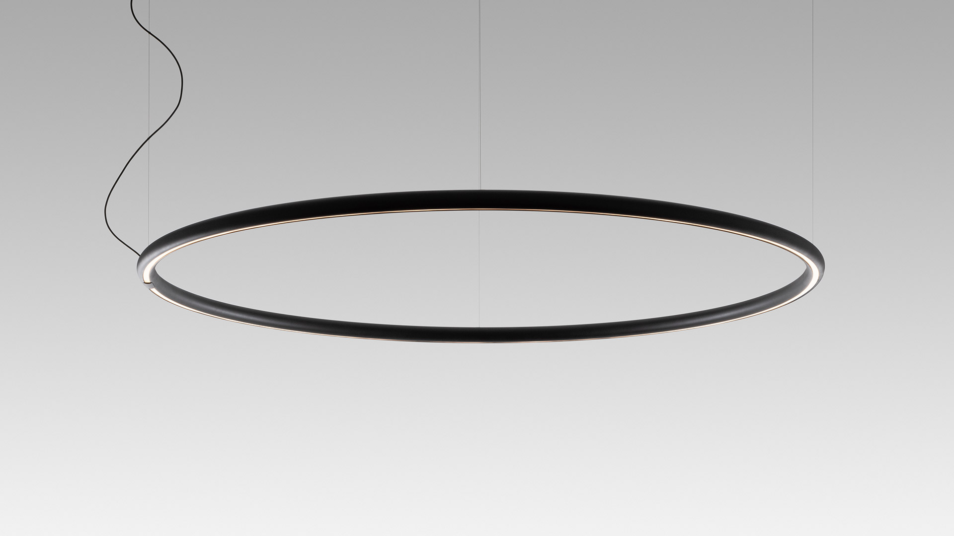 Artemide Alphabet of Light circular pendant lamp in matte black, large ring shape with integrated LED strip, suspended by cables