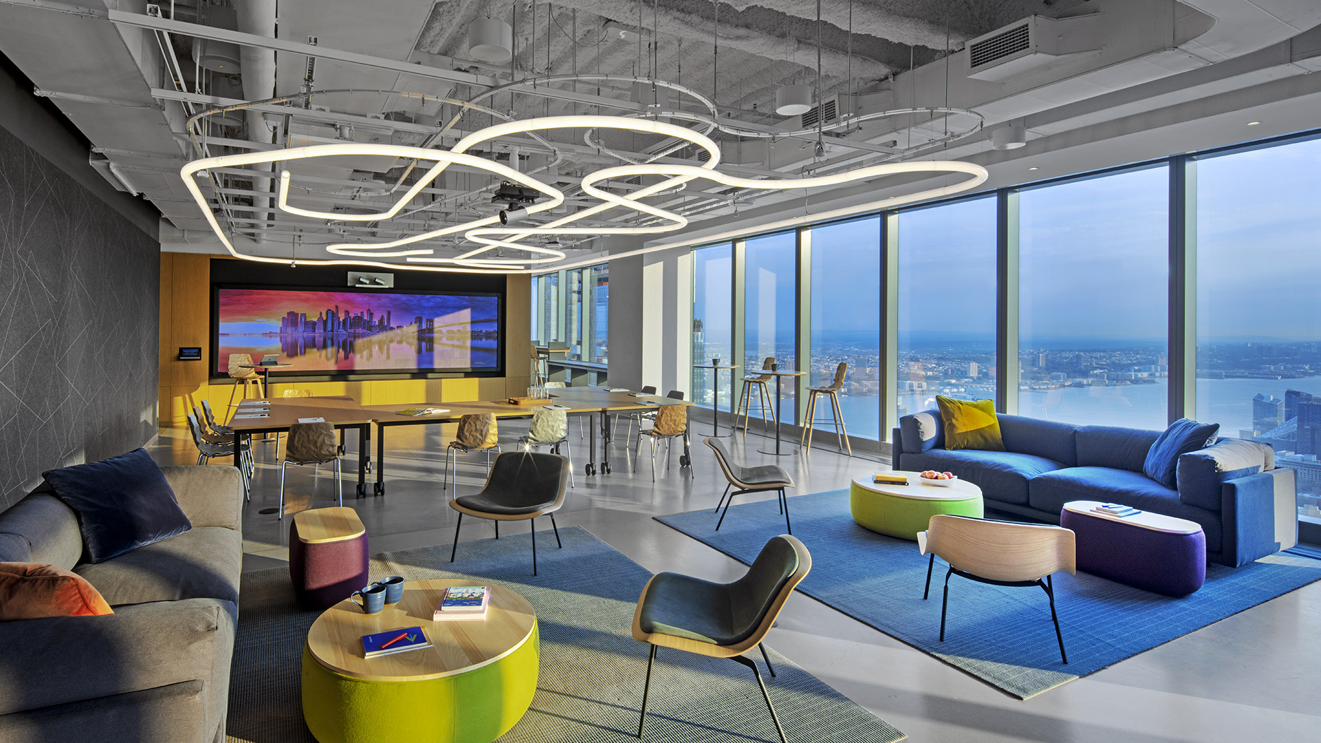 Modern office lobby with Artemide Alphabet of Light linear and circular ceiling installations, white marble floors, and blue artistic wall.