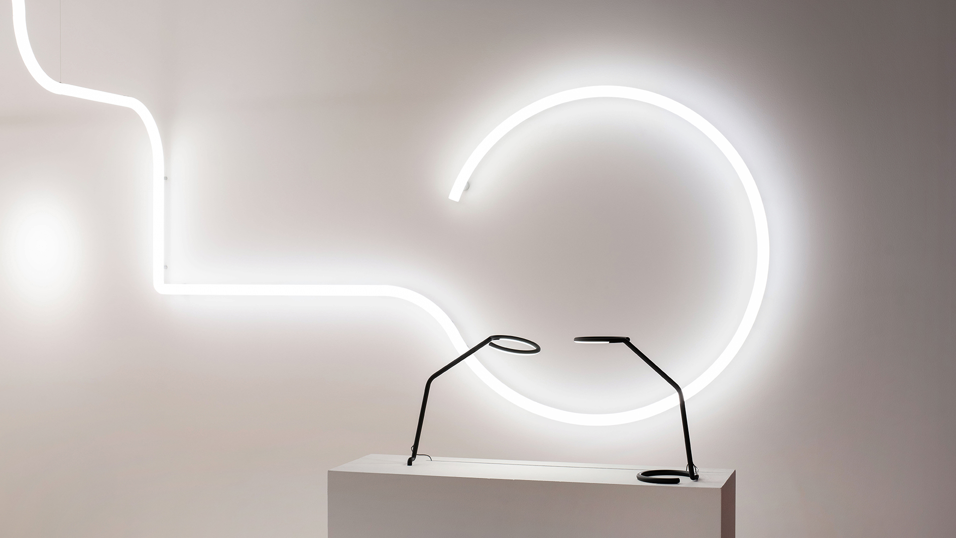 Artemide Alphabet of Light System: white linear LED tubes arranged in geometric pattern against deep red illuminated wall