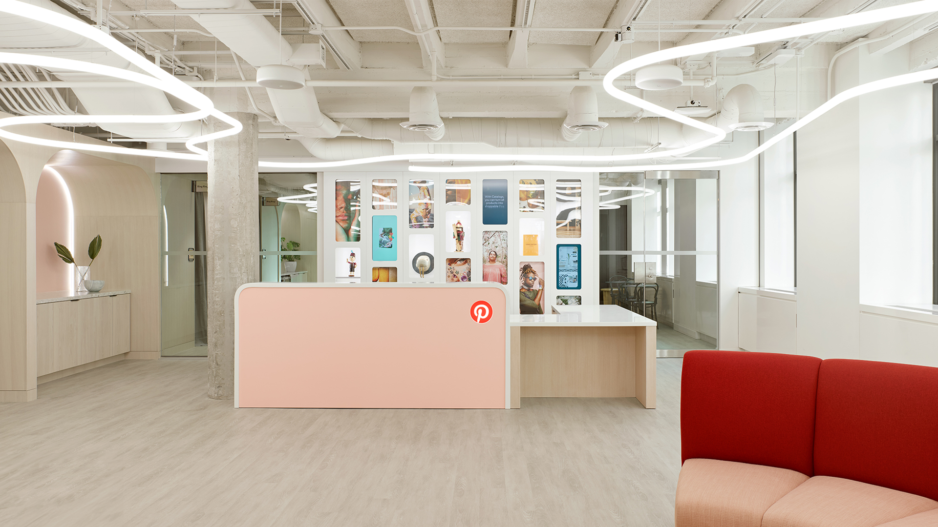 Modern office lounge with Artemide Alphabet of Light System pendant installation, colorful seating, and panoramic city views at dusk
