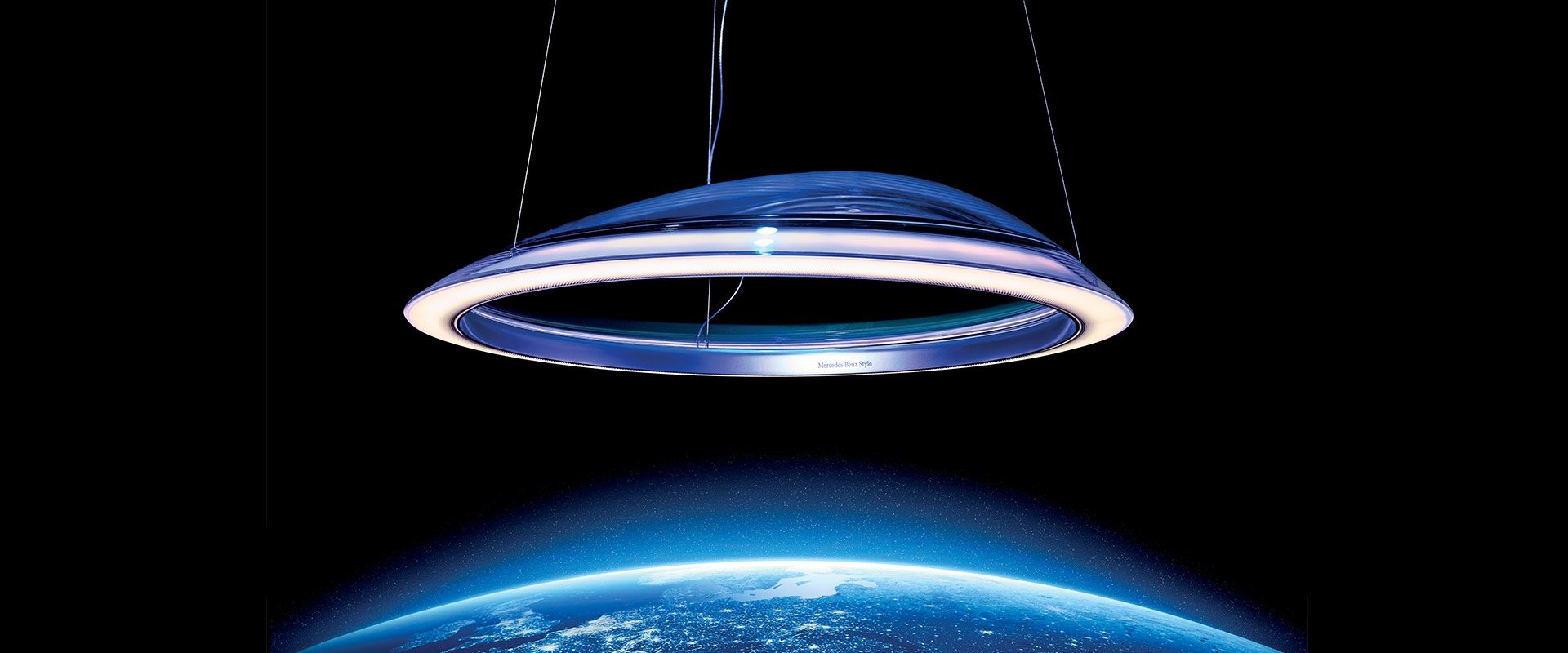 Artemide Ameluna pendant lamp, circular LED ring in polished aluminium, suspended against a dark sky above planet Earth