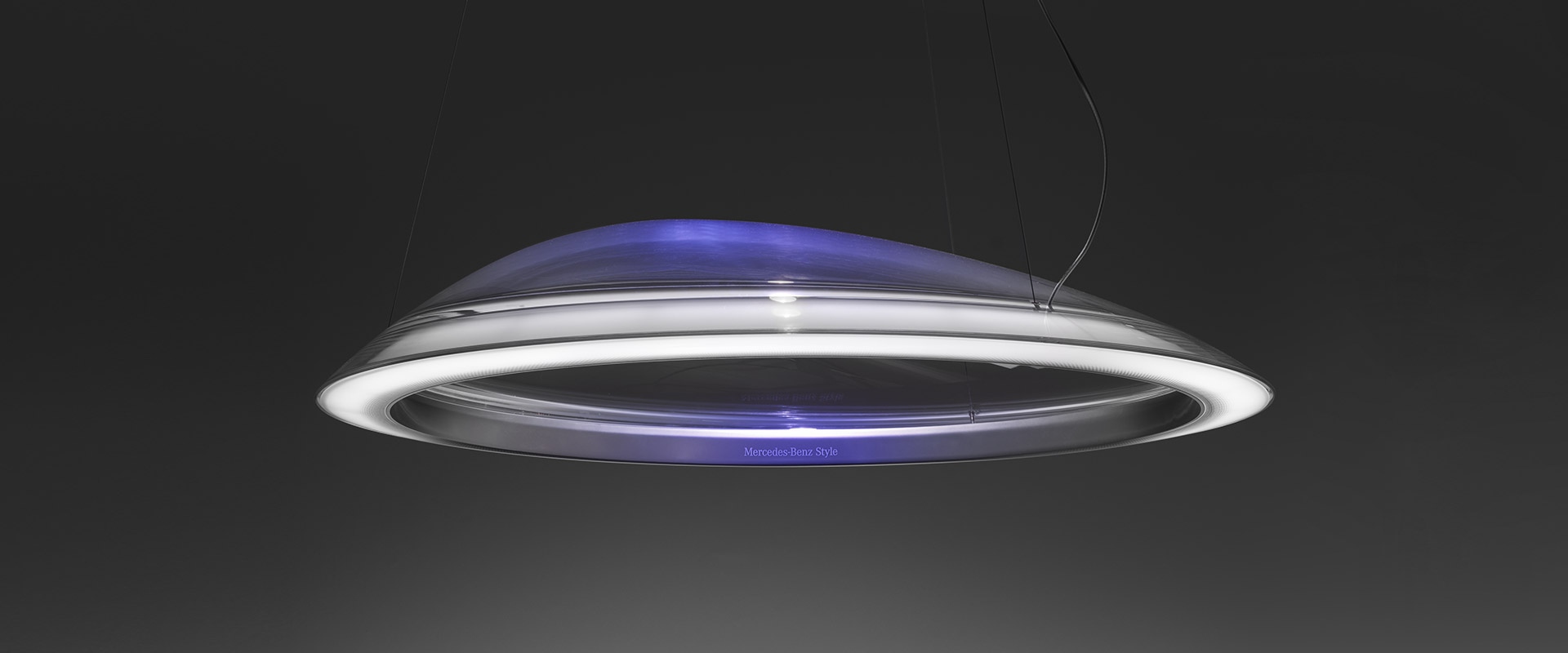 Artemide Ameluna pendant lamp: sleek disc-shaped design with chrome ring, glowing blue LED inner dome, suspended by thin cable