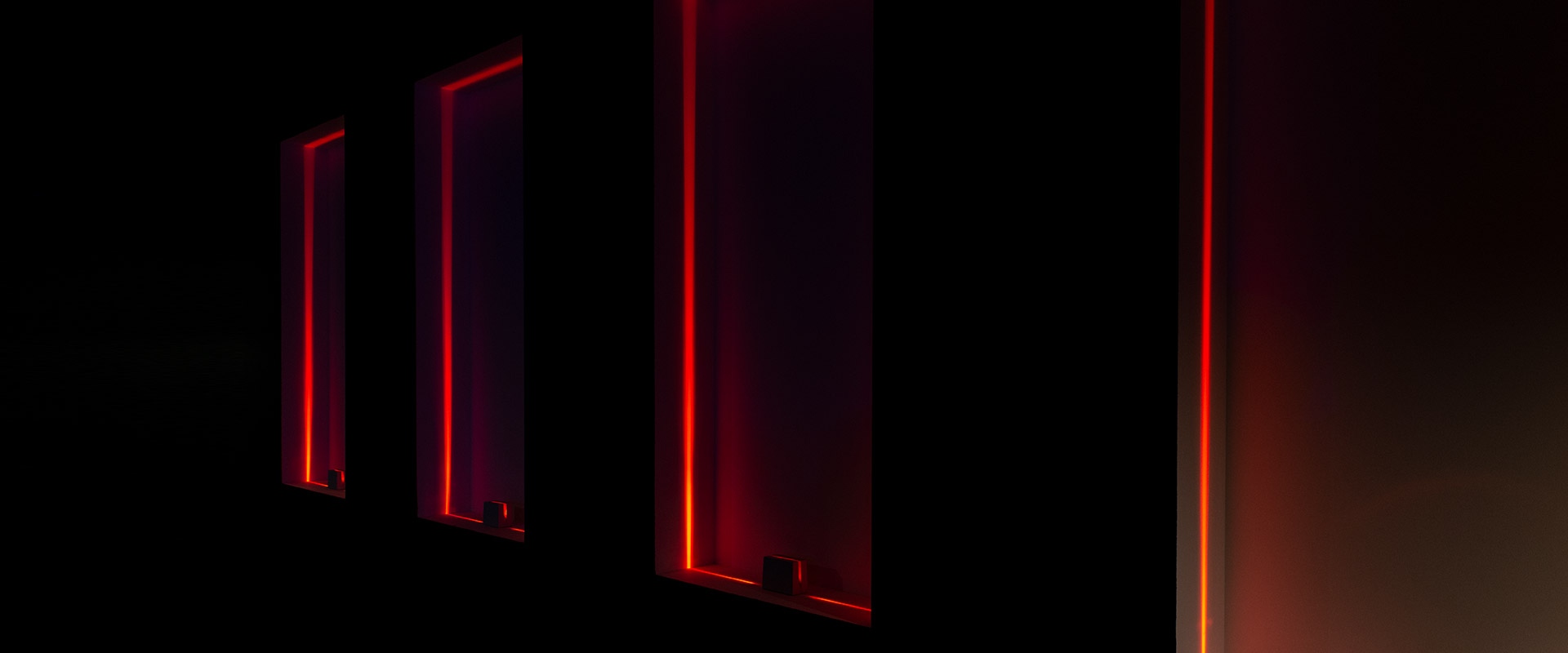 Antarktikós by Artemide: compact white rectangular LED floor light emitting a subtle linear glow on a reflective white surface