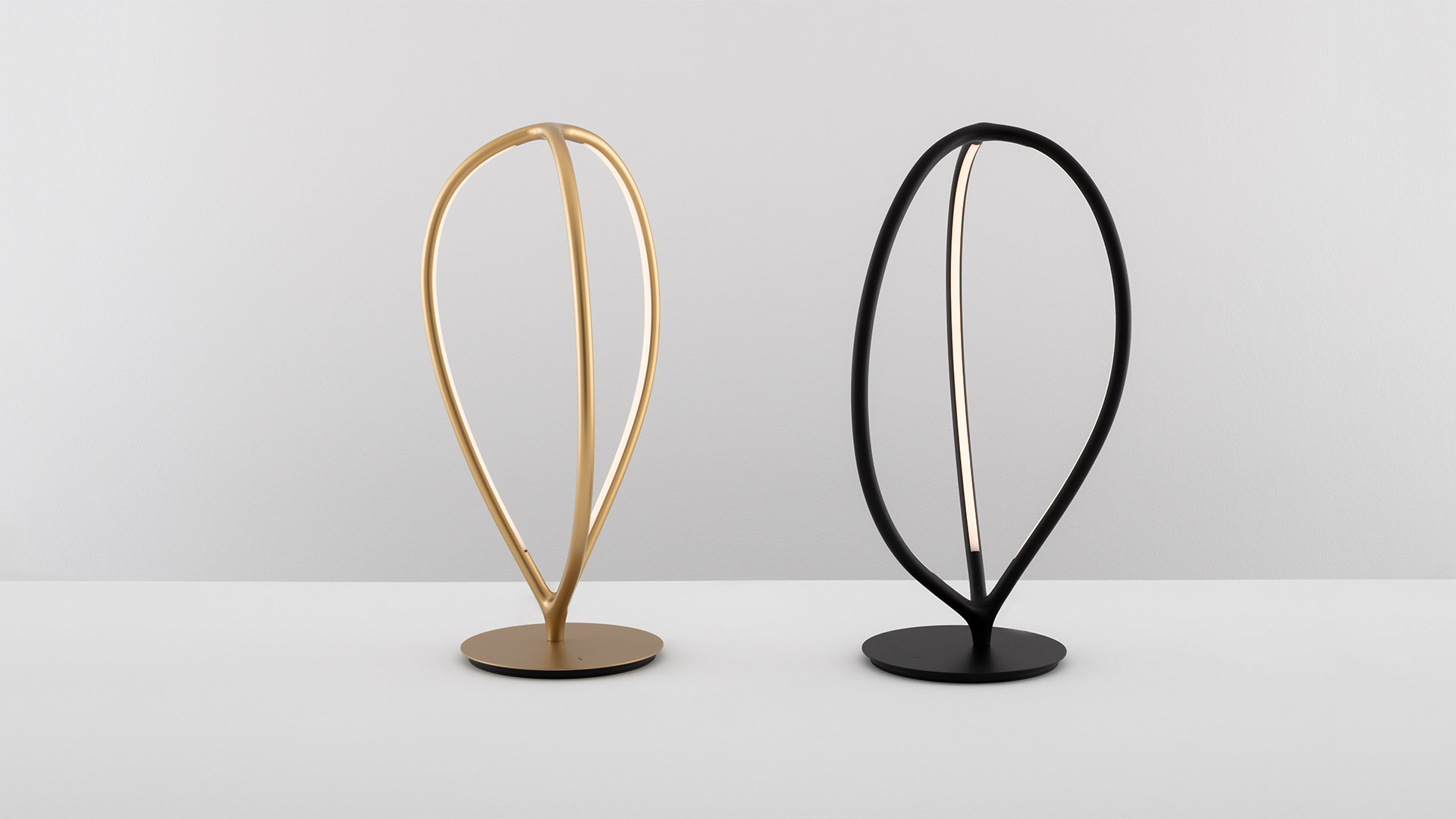 Artemide Arrival lamps in black: two ceiling pendants, one table lamp on cube, one floor lamp with oval looped LED frames
