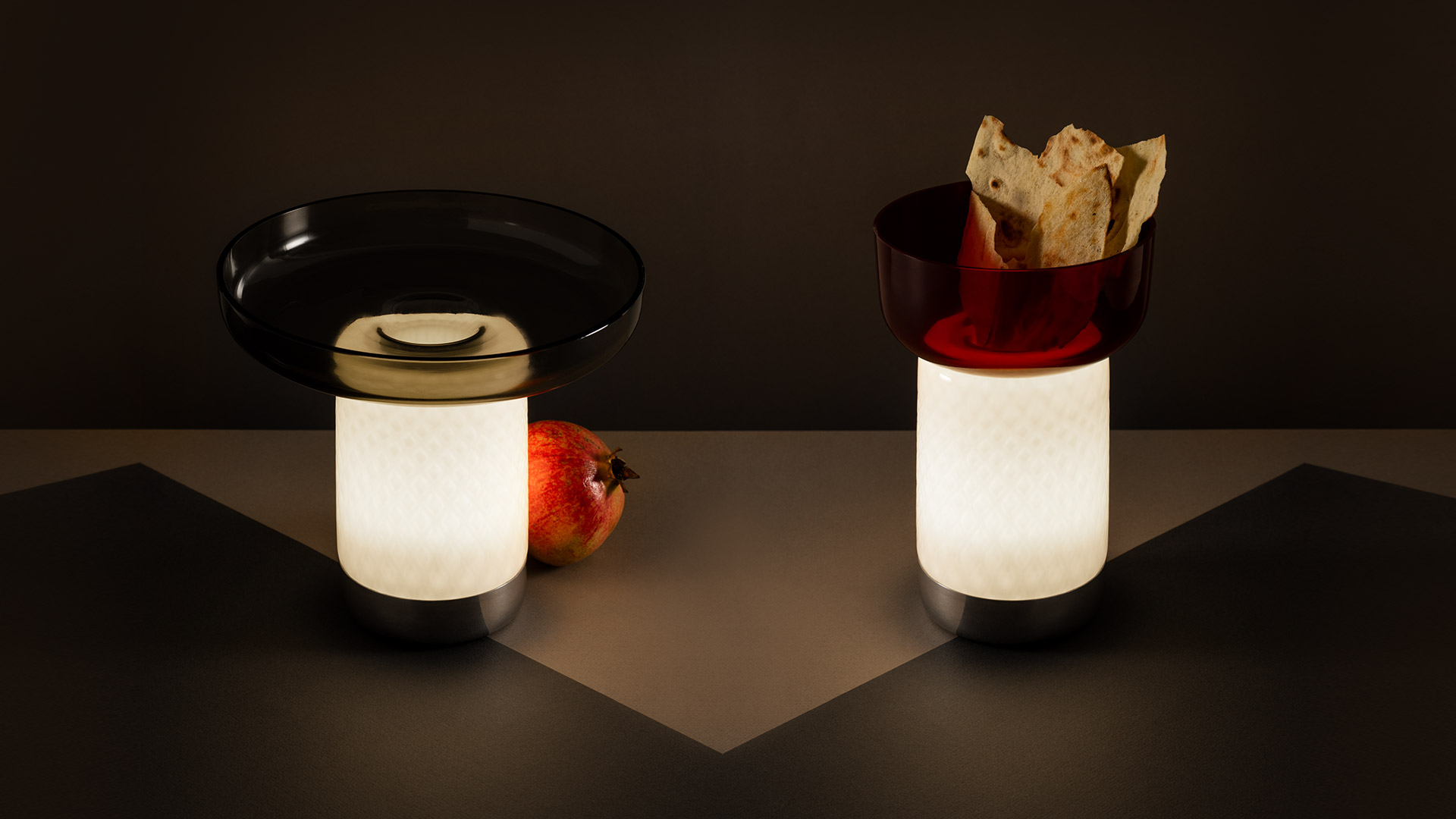 Artemide Bontà table lamps in four configurations: colored glass disc shades in red, aqua, and amber tones with glowing cylindrical bases