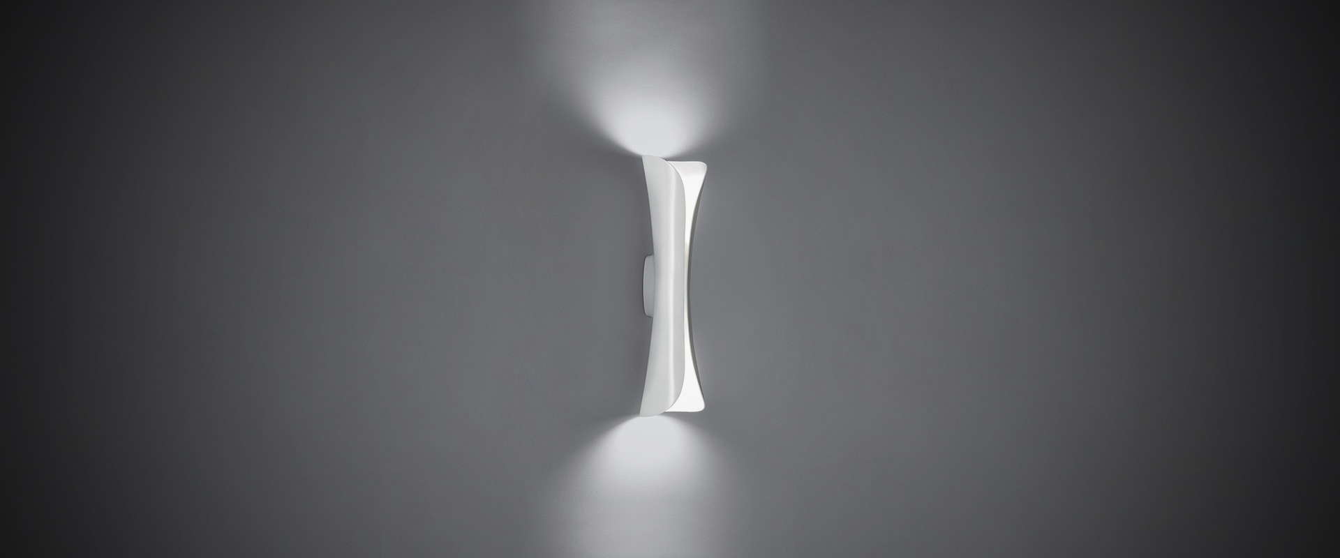 Artemide Cadmo floor lamp with dark metallic petals opening upward, emitting warm indirect light from its tulip-shaped diffuser