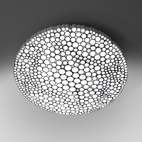 Artemide Calipso ceiling lamp with round diffuser featuring a pattern of varying-sized circular openings emitting soft white light