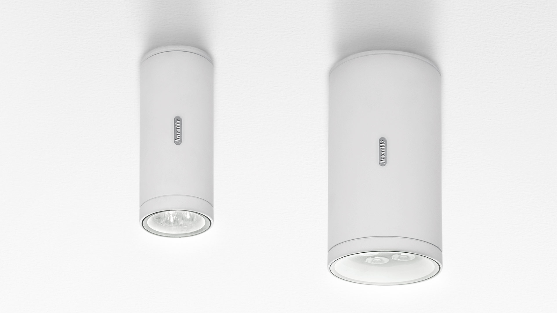 Two Artemide Calumet ceiling spotlights in white, cylindrical shape, surface-mounted, shown in small and large sizes
