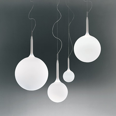 Four Artemide Castore pendant lamps with white opal glass spheres in varying sizes, suspended by thin cables with tapered metal tops