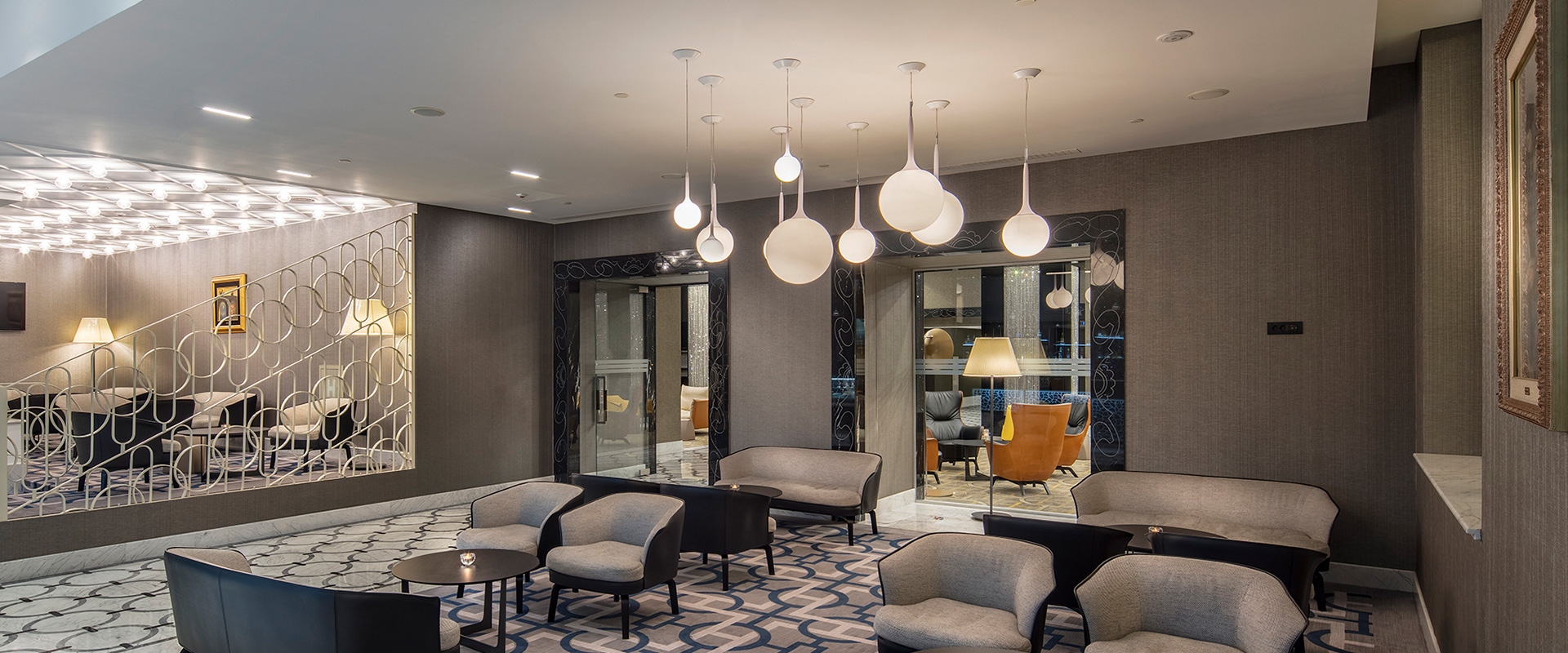 Cluster of seven Artemide Castore pendant lamps with opal white spherical glass diffusers in varying sizes hanging from white ceiling
