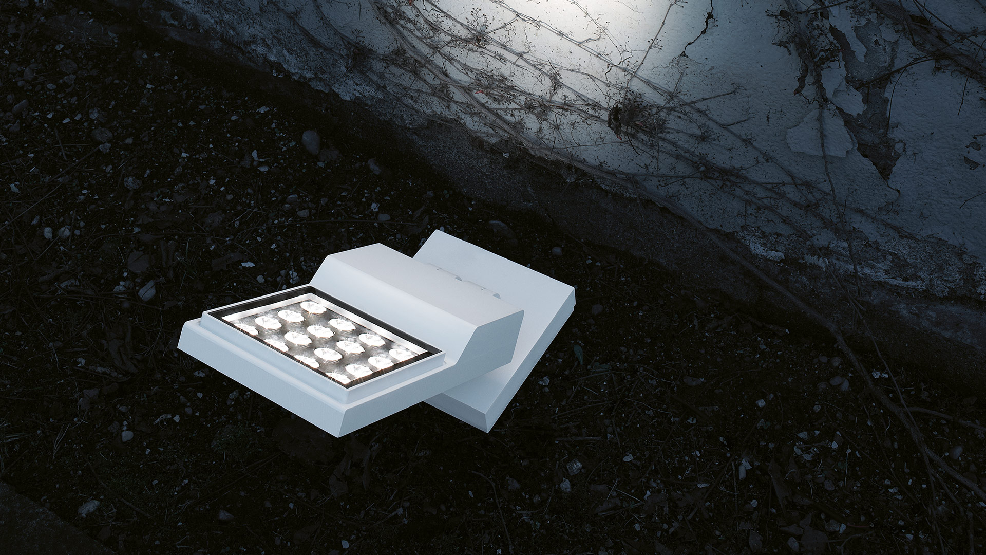 Artemide Cefiso outdoor LED ground fixture in white, featuring a grid of LED modules, installed on dark ground near water