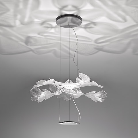 Artemide Chlorophilia pendant lamp: white leaf-shaped diffusers arranged in a floral cluster, casting organic shadow patterns on the ceiling