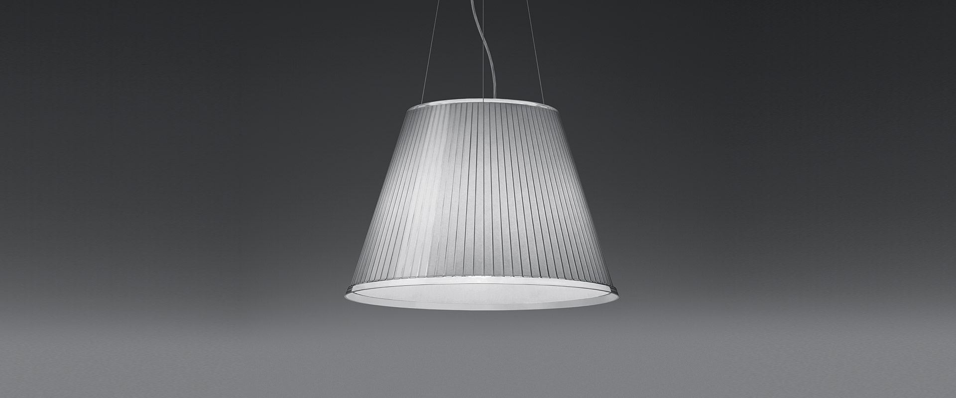 Two Artemide Choose floor lamps on chrome stems: left with upright white conical shade, right with tilted beige shade