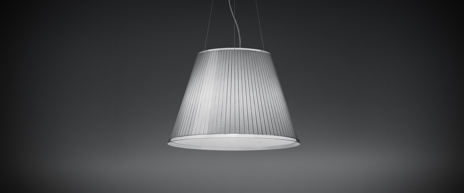 Artemide Choose Mega pendant lamp with pleated silver fabric shade, conical shape, suspended by thin cables on grey background
