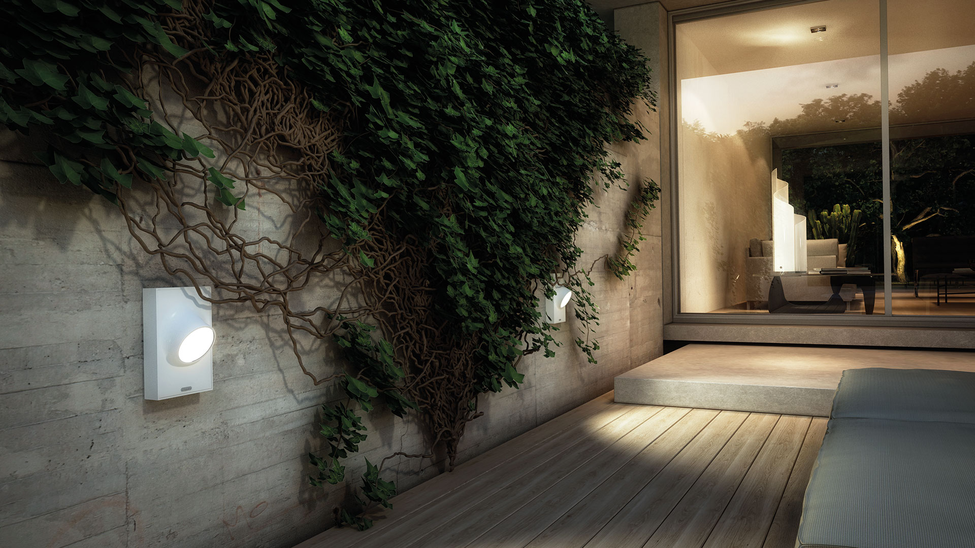 Artemide Ciclope outdoor wall lamp mounted on a concrete wall with ivy, casting warm light on a wooden deck terrace at dusk