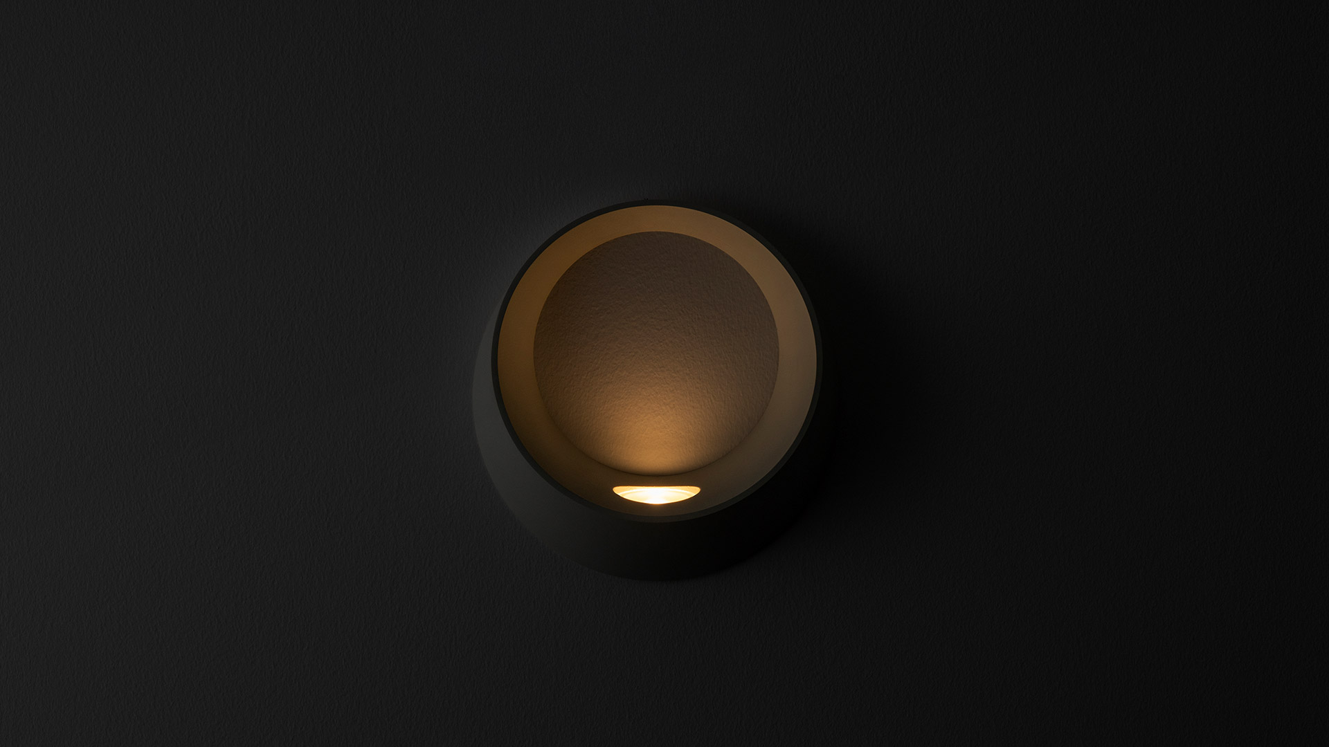 Artemide Cleomede wall/ceiling lamp, white cylindrical shade emitting warm diffused light, mounted at wall-ceiling corner