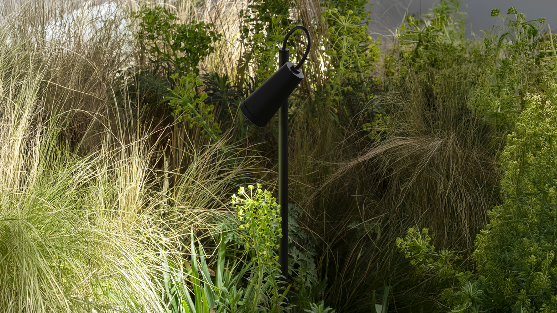 Three Artemide Conus lamps in red, dark grey, and green, featuring adjustable spotlight heads on floor stand and plug-in base versions