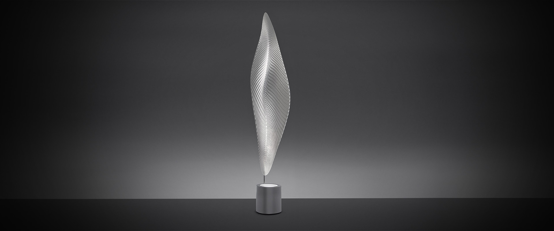 Artemide Cosmic Leaf floor lamp: tall sculptural leaf-shaped diffuser in transparent mesh on a cylindrical metallic base