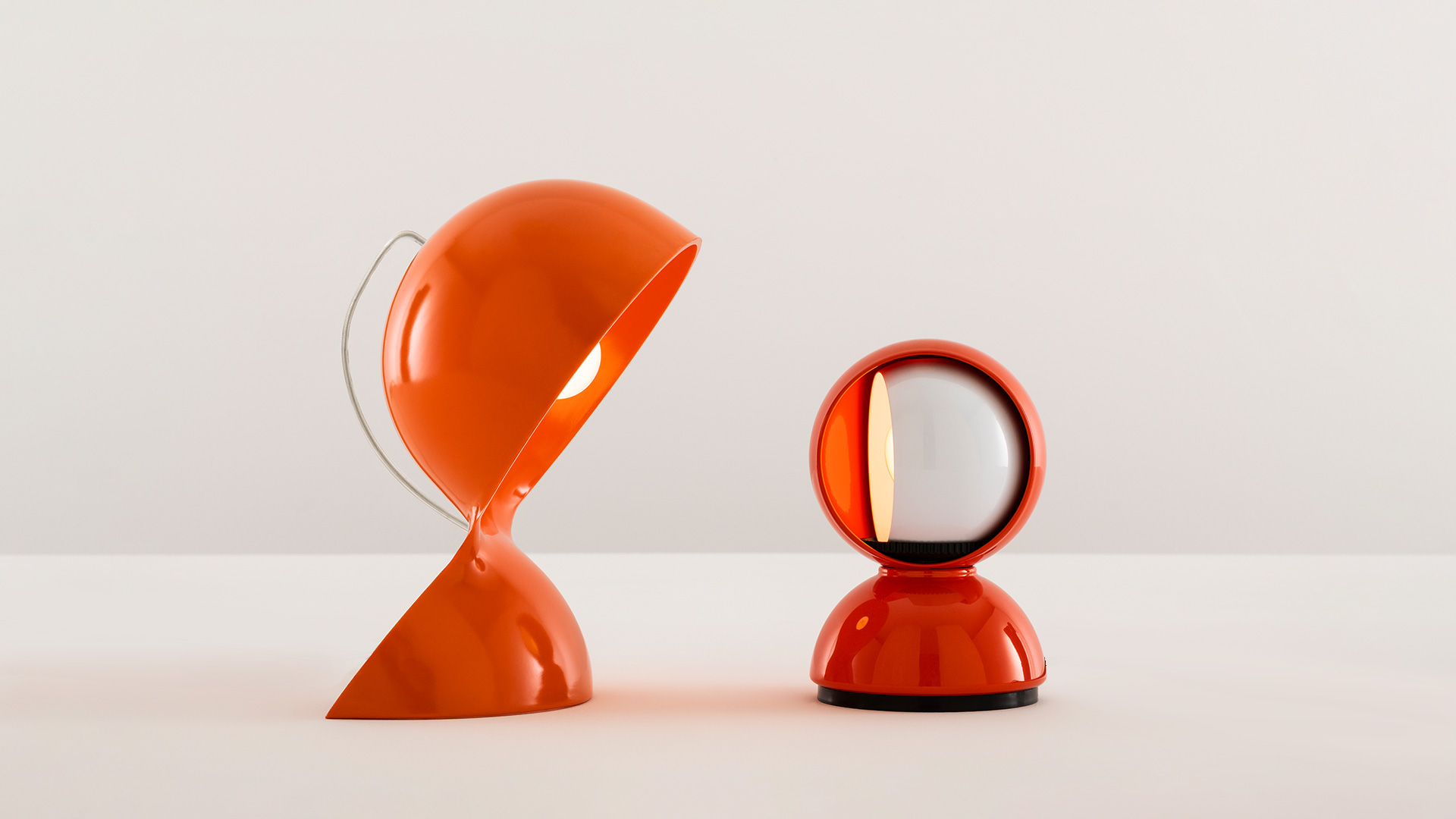 Artemide Dalù table lamp collection in dark red: sculptural rounded forms with circular opening, shown in multiple sizes on white display
