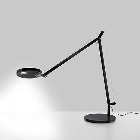 Artemide Demetra table lamp in black, featuring a circular LED head, articulated arm with tension wire, and round base