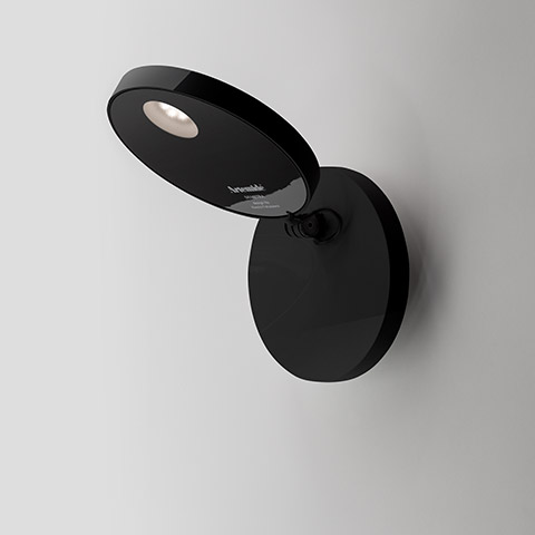 Artemide Demetra Faretto black wall spotlight with adjustable oval head and integrated LED, mounted on a round wall base
