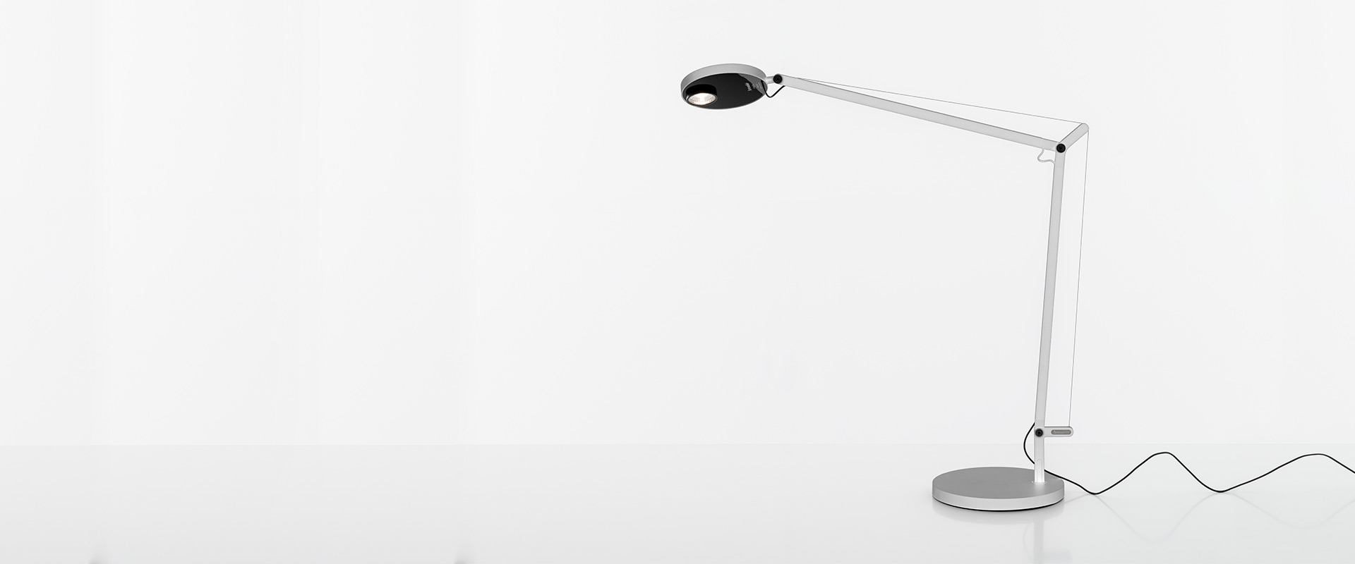 Artemide Demetra Professional table lamp in silver aluminium with articulated arm, circular LED head, and round base on white background